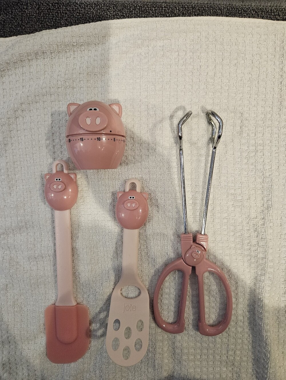 Jo!e pink pig tongs, timer, frosting spatula and very small spatula.
